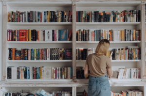 Woman looking at bookshelf in her home installed by Top Shelf UK